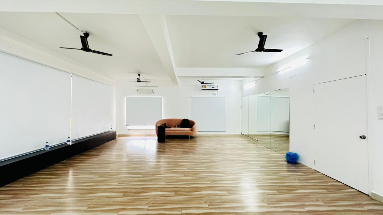 Mirrored studio wall, open floor area and lounge sofa