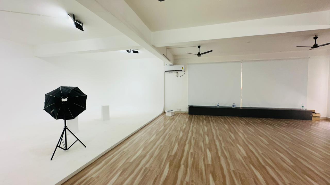 Wide studio shooting area with wood flooring and window blinds